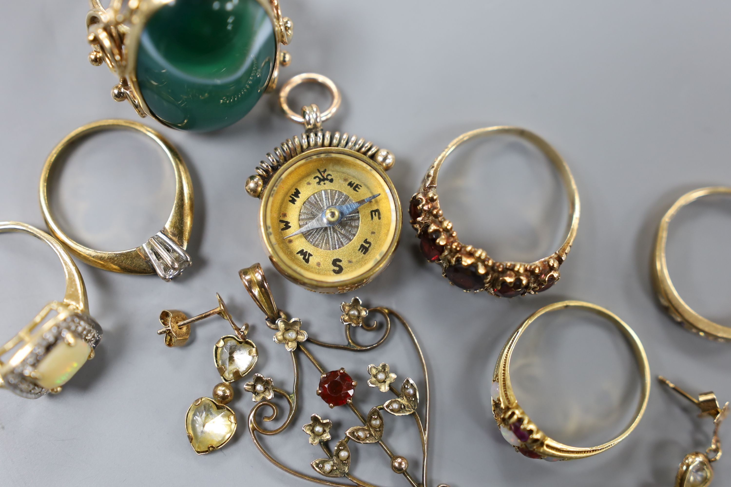 Five assorted modern 9ct gold and gem set rings, a 9ct gold mounted compass fob, a 9ct and gem set pendant and pair of 375 earrings, gross 26.7 grams, together with two yellow metal and gem set rings including five stone